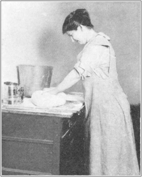 A Blackburn College student mixing bread