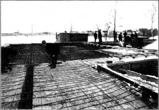 Reinforcement in Place Over One Complete Floor of Storage Warehouse. Slabs, 14 Ft. Square. Reinforced Two Ways. Note Continuity of Reinforcement and Elevation Over Supports. Floor Designed for 150 Lb. per Sq. Ft. Live Load. Tested to 900 Lb. per Sq. Ft.