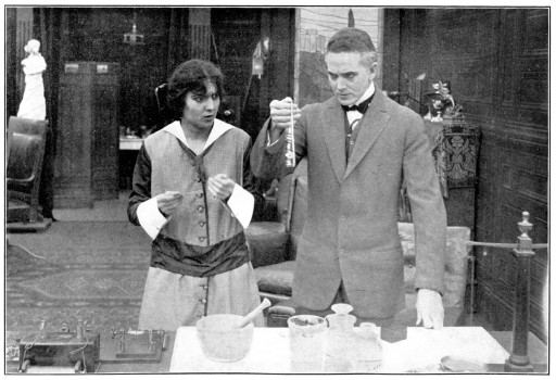 A man and a woman look at a necklace.