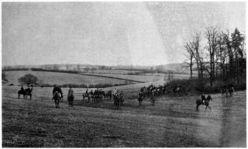 A hunt in an open field, near a wooded patch