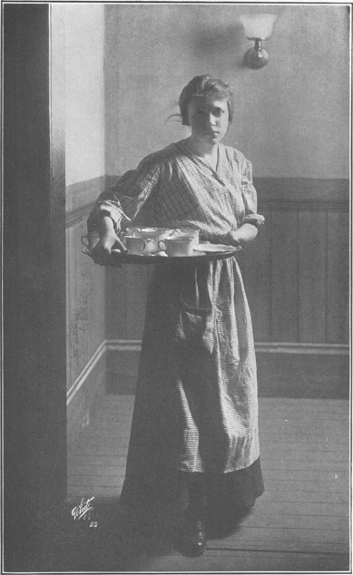 Judy in gingham, carrying a tea tray