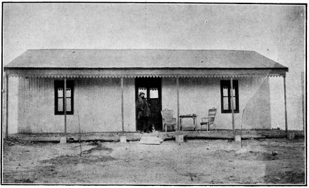 LA PREMIÈRE MAISON DE LA «COLONIA CERVANTES», EN BOIS, DÉMONTABLE, REVÊTUE DE TÔLES DE ZINC ONDULÉ  Blasco a été photographié sur le seuil de cette baraque