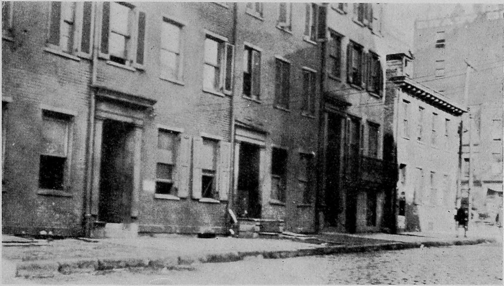 A Row of Dilapidated Old Dwellings in the Downtown Section Used as Rooming Houses for Migrants.