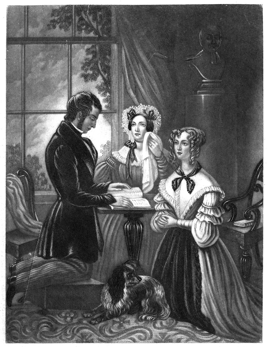 two ladies and a man kneeling around a small table