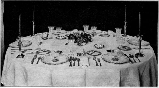 Photo by Bradley and Merrill. Courtesy of the Pictorial Review.  TABLE SET FOR DINNER  The decoration in the center of the table should never be so high as to form an obstruction