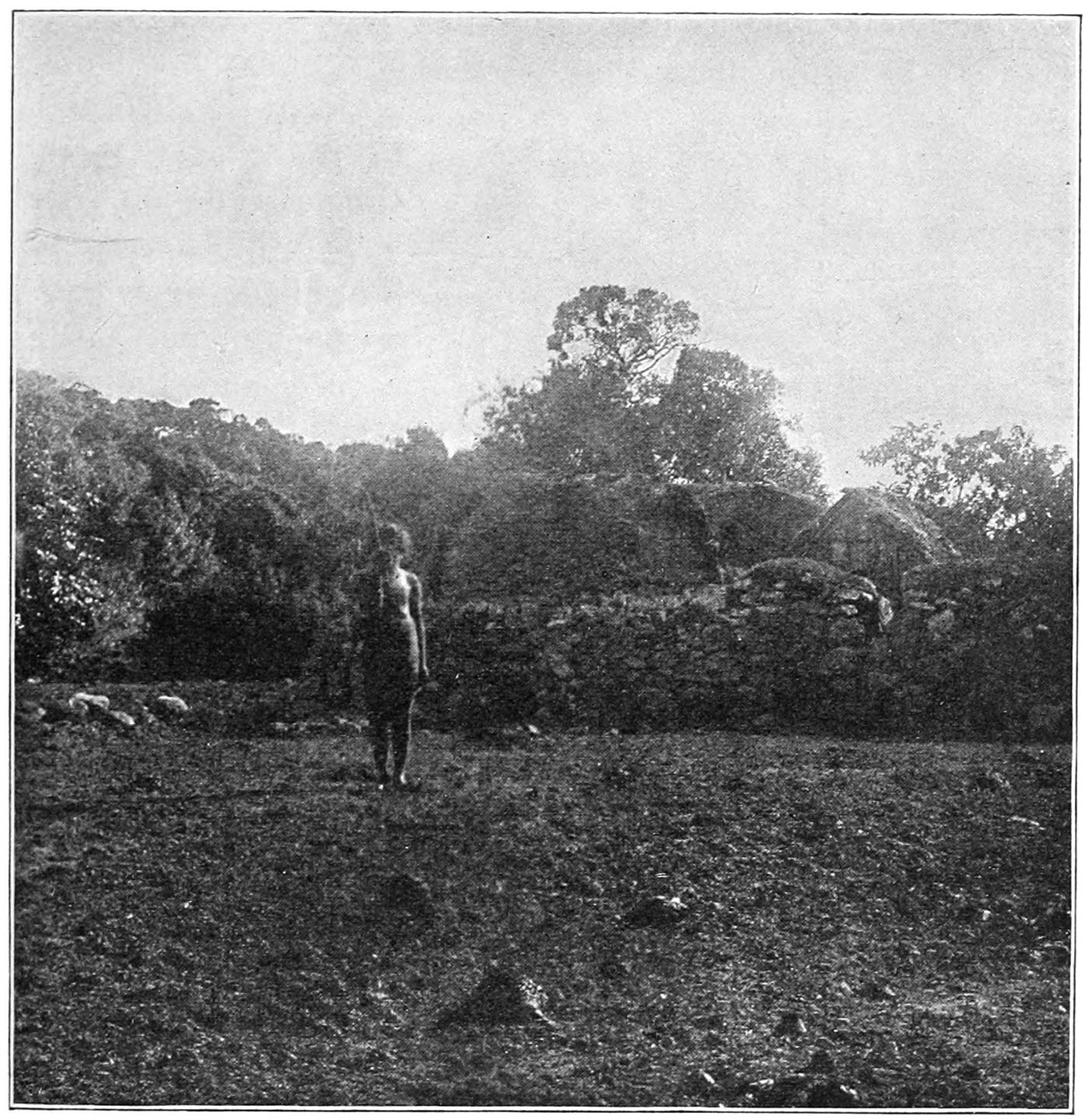 FIG. 27.—THE ‘PALOL,’ KARKIEVAN, SALUTING AT MÒDR. HE IS STANDING IN THE ‘PEPKARMUS.’ THE BUILDING NEXT TO THE ‘PALOL’ IS THE ‘TI POH’; THAT ON THE RIGHT IS THE ‘KARENPOH,’ AND BETWEEN IT AND THE ‘TI POH’ CAN BE SEEN THE HUT WHERE THE INHABITANTS OF THE ‘TI MAD’ SLEEP.