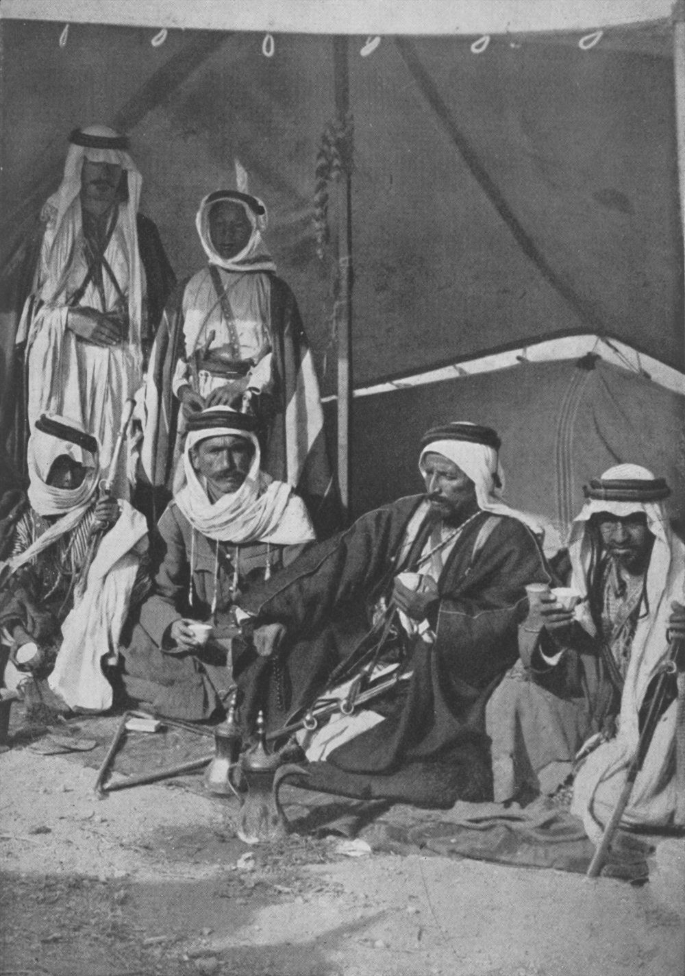 Photo wide shot of four seated men in Arab dress