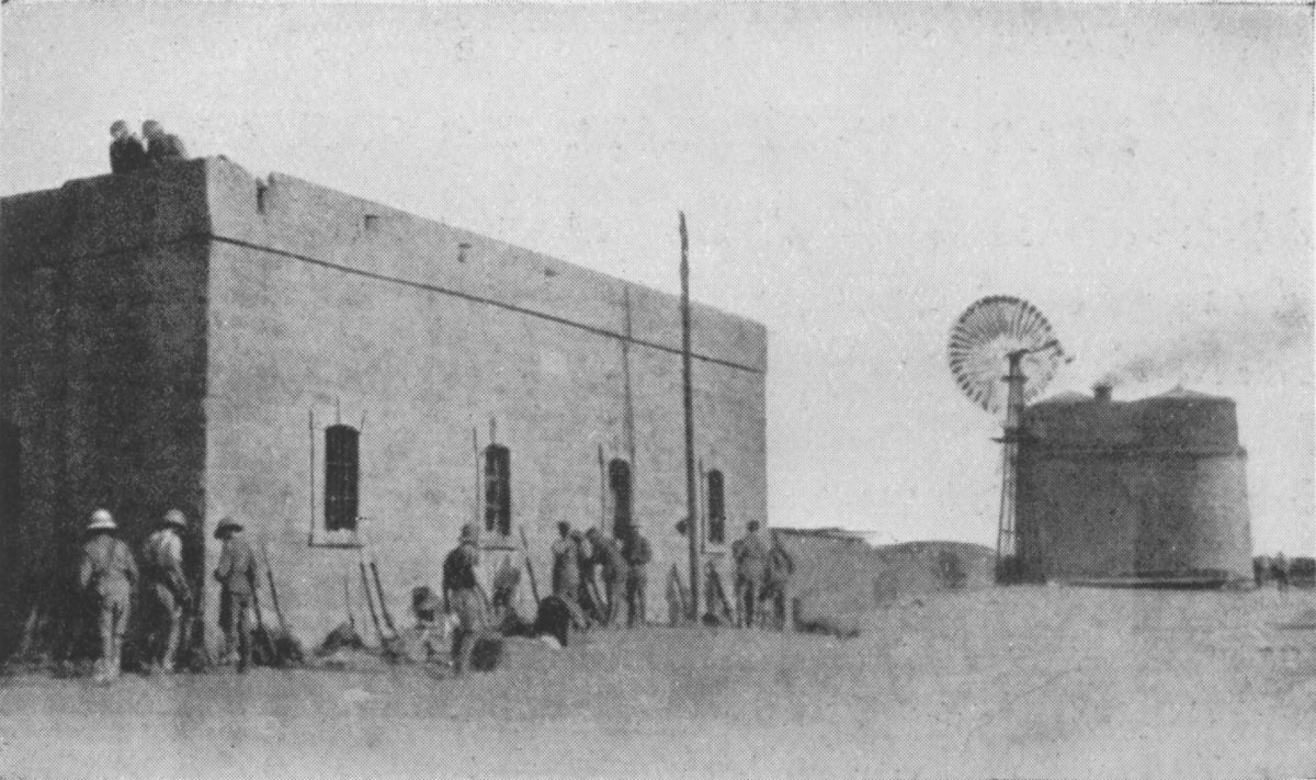 Photo wide shot of men surrounding a building
